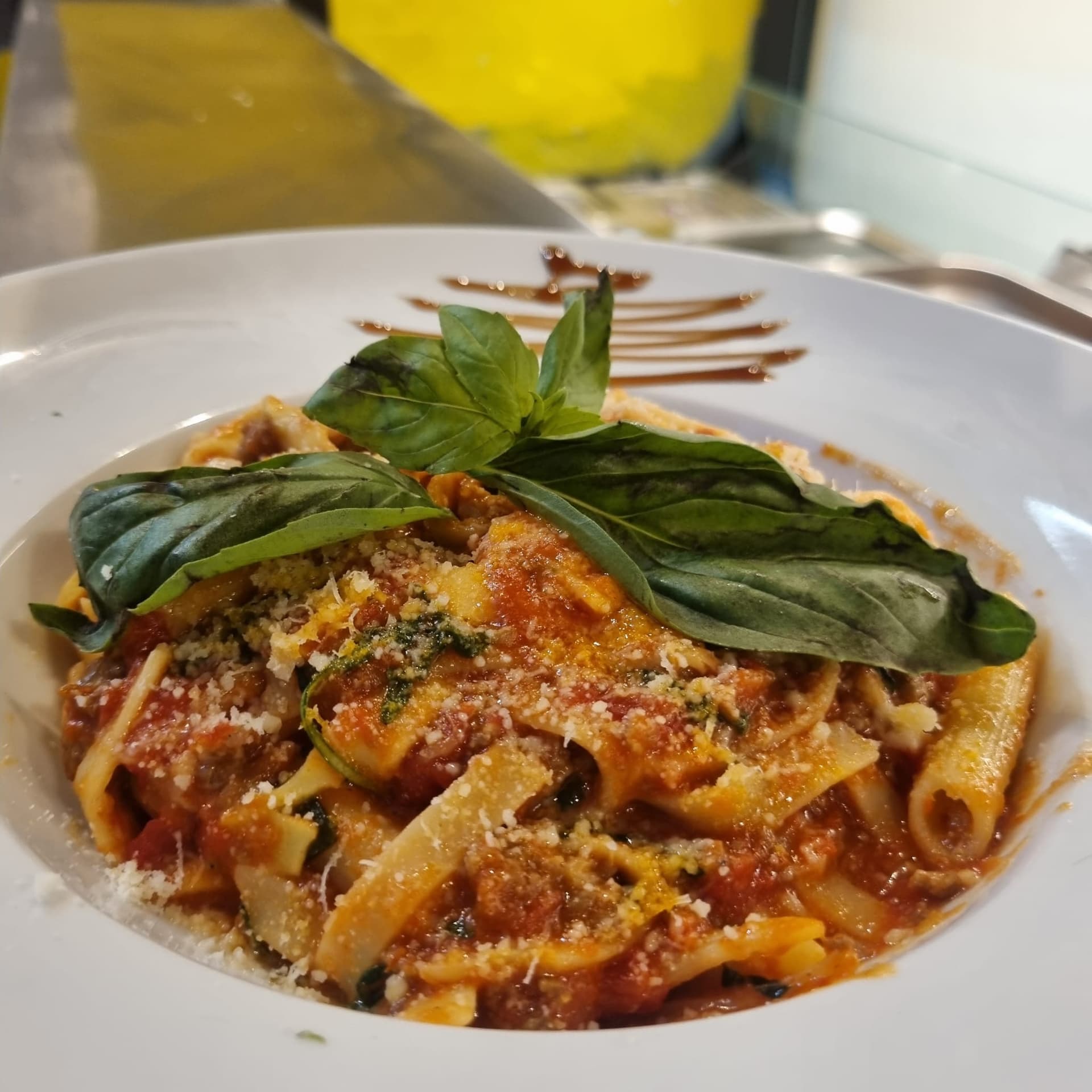 Bord pasta met tomatensaus en verse basilicum op de toonbank van Pasta Express in Etterbeek